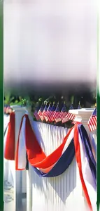 Patriotic red white and blue tricolor bunting on a white fence for Independence Day.