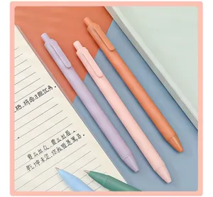 Detailed macro view of colorful matte 0.5mm retractable gel pens on a notebook prop