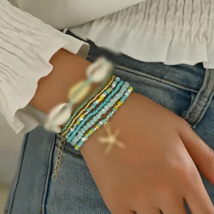 Close-up of Bohemian beaded bracelet set with shell and starfish pendants on wrist
