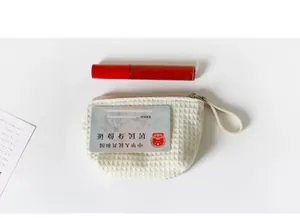 Portable waffle texture coin purse shown alongside a lipstick for size reference