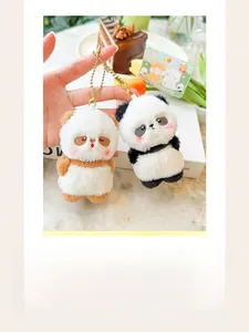 Detail view of cute mini panda and bear magnetic plush keychains held in hand