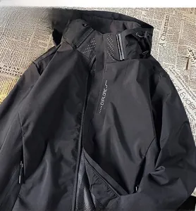 Close-up detail of a black windproof functional jacket with white EXPLORE print on chest