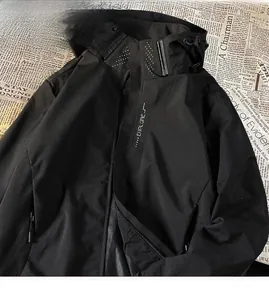 Detail view of a black windproof waterproof outdoor hiking jacket with techwear style