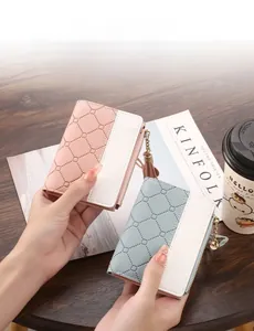 Close-up of stylish two-tone quilted bi-fold wallets featuring secure zipper and tassel detail