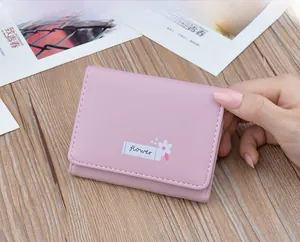 Close-up of pink soft leather woman's wallet with flower print and stitch details