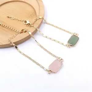 Close-up detail of natural pink and green rectangular stone bracelets with gold adjustable chains.