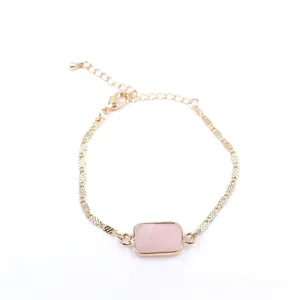Close-up of golden chain bracelet featuring a faceted rectangular pink rose quartz