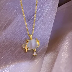 Gedetailleerd zicht op een gouden wolkenketting met bliksem en kristallen druppel
