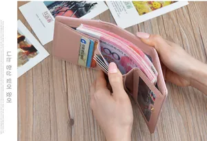 Detail view of a pink trifold leather wallet showing its large capacity for cash and cards.