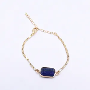 Close-up detail of a square blue lapis lazuli stone set on a gold adjustable chain bracelet