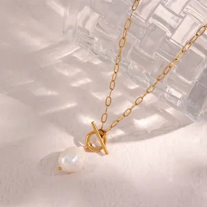 Close-up view of a natural baroque pearl pendant on a vintage gold toggle clasp necklace