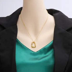Detail view of a gold geometric rectangular pendant necklace on a mannequin