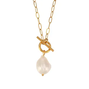 Detail of baroque pearl necklace with gold toggle clasp and paperclip chain.