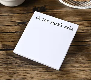 Detailansicht eines weißen Haftnotizblocks mit einem lustigem Spruch auf Holzgrund