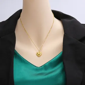 Detail shot of a golden heart pendant necklace in 18k gold plated stainless steel