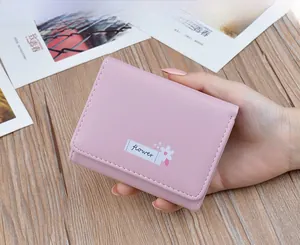 Detailed macro shot of a cute pink soft leather slim folding wallet for women.