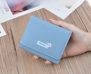 Close-up detail of a stylish light blue soft leather foldable wallet for women.