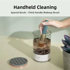 Detail of electric makeup brush cleaner washing a thick brush in a water container