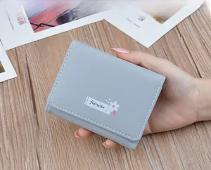 Elegant short gray tri-fold faux leather wallet for women with small flower detail