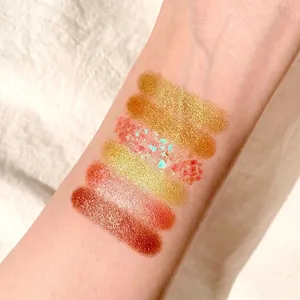 Macro view of six shimmer and glitter eyeshadow swatches on a forearm for color testing