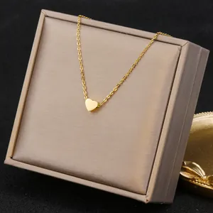 Close-up of a minimalist gold heart pendant necklace on a jewelry display box