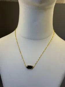 Dettaglio di una collana placcata oro 18K con un ciondolo rettangolare in pietra nera lucida.