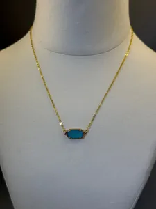 Dettaglio di una collana placcata in oro 18 carati con pendente ovale in pietra blu