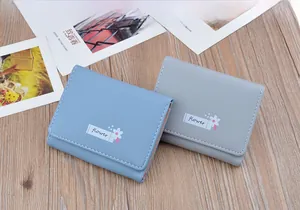 Detailed view of short folding soft leather wallets in blue and grey with flower pattern