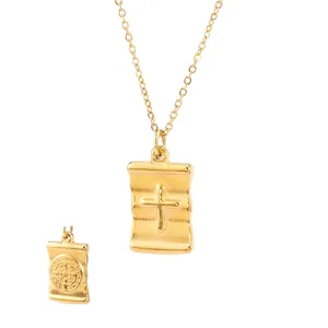 Detailed view of gold-plated scroll pendant with cross and religious medal.