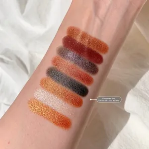 Close-up macro view of vibrant shimmer eyeshadow swatches on skin in warm earth tones