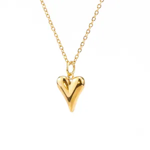 Detailed macro view of polished gold plated heart shaped pendant on a fine chain.