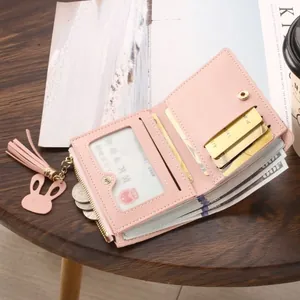 Slim pink bifold short wallet for women featuring a rabbit tassel and multiple card slots