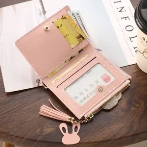 Slim pink bi-fold wallet for women with zipper coin pocket and cute rabbit charm.