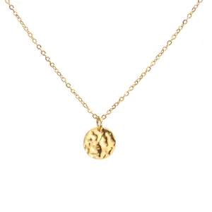 Detailed view of a gold-plated link chain with a hammered circular coin pendant