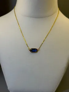 Dettaglio di una collana con pietra portafortuna placcata oro 18K con gemma blu.