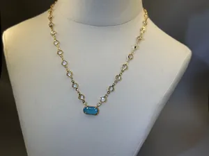 Vista dettagliata di una collana con pietra portafortuna placcata in oro 18K e ciondolo blu