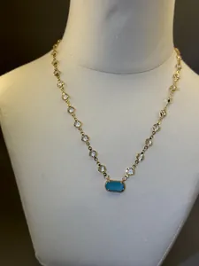 Dettaglio della collana placcata oro 18K con ciondolo turchese e catena di cristalli.