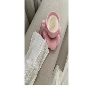 Detail view of an elegant pink ceramic coffee cup with a creative flower-shaped saucer