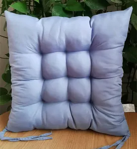 Detailed view of a light blue tufted square chair cushion with fabric securing ties