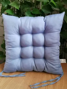 Close-up detail of a soft light purple tufted square chair cushion with seat ties.