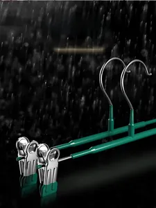 Detail view of anti-rust stainless steel pant hangers with green non-slip clips in rain