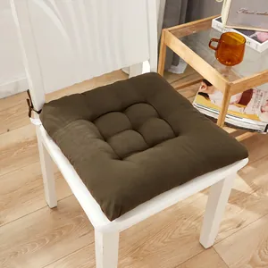 Detailed close-up of a soft dark brown tufted seat cushion with ties on a white chair