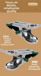 Close-up of stainless steel pants clips with green rubber tips for non-slip grip.