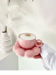 Close-up detail of a minimalist pink flower-shaped ceramic coffee cup and saucer set