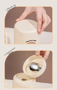 Detailed view of opening the beige mug lid to reveal the built-in folding spoon
