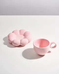 Minimalist pink ceramic coffee cup with matching flower-shaped saucer detail