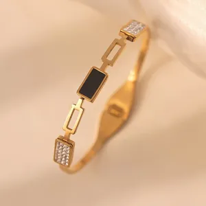 Eleganter Armreif aus Gold-Titanstahl mit schwarzem Rechteck-Inlay und funkelnden Kristallen