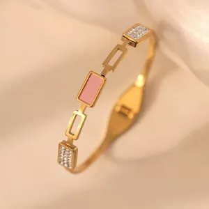 Eleganter vergoldeter Titanstahl-Armreif mit rosa Emaille-Mitte und funkelnden Kristallen