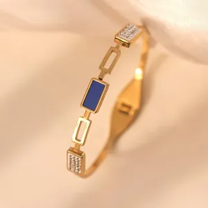 Eleganter vergoldeter Edelstahlarmreif mit blauem Emaille und funkelnden Kristallen.