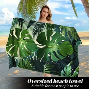 Dettaglio dell'asciugamano da spiaggia con stampa foglie di Monstera e design tropicale